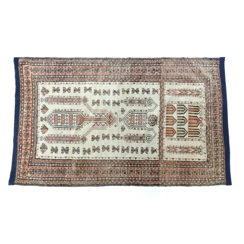 1380 - Carpet / Rug: A beige ground rug with repeated motifs worked in salmon pink, brown and beige, with b... 