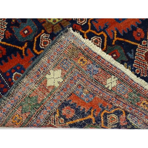 1382 - Carpet / Rug: A blue ground rug decorated with repeating geometric motifs of stylised floral and fol... 