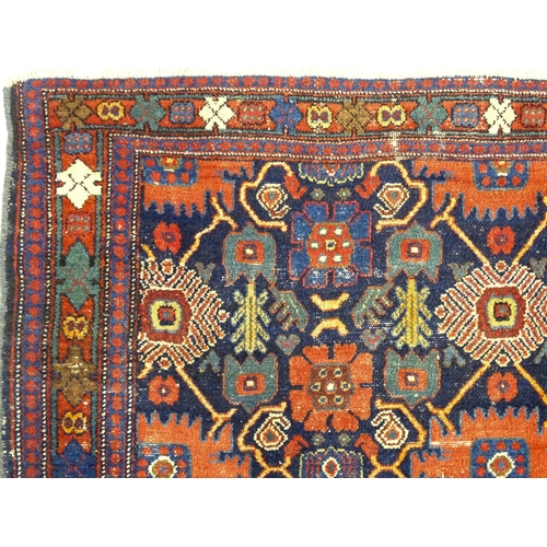 1382 - Carpet / Rug: A blue ground rug decorated with repeating geometric motifs of stylised floral and fol... 