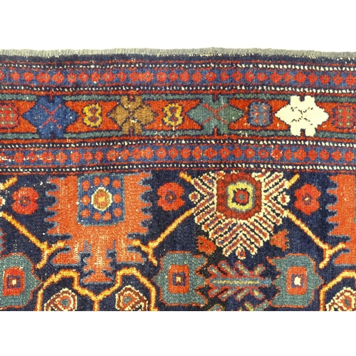 1382 - Carpet / Rug: A blue ground rug decorated with repeating geometric motifs of stylised floral and fol... 