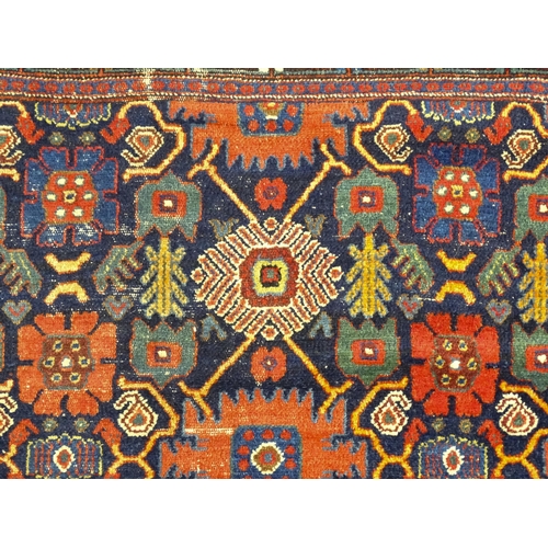 1382 - Carpet / Rug: A blue ground rug decorated with repeating geometric motifs of stylised floral and fol... 