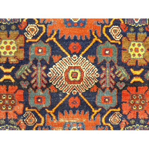 1382 - Carpet / Rug: A blue ground rug decorated with repeating geometric motifs of stylised floral and fol... 