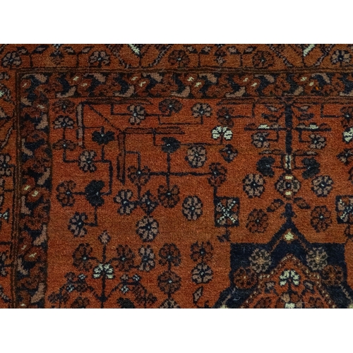 1383 - Carpet / Rug: A red ground rug decorated with floral and foliate detail, further repeated to borders... 