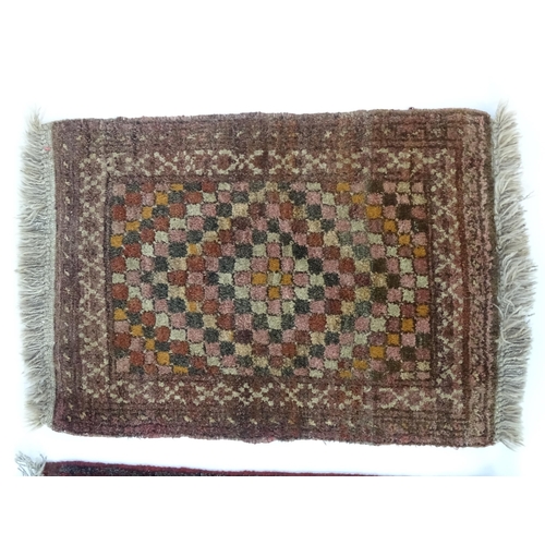 1384 - Carpets / Rugs: Two small rugs, one with burgundy ground with repeating motifs, the other with salmo... 