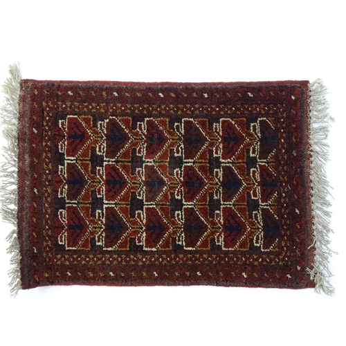 1384 - Carpets / Rugs: Two small rugs, one with burgundy ground with repeating motifs, the other with salmo... 