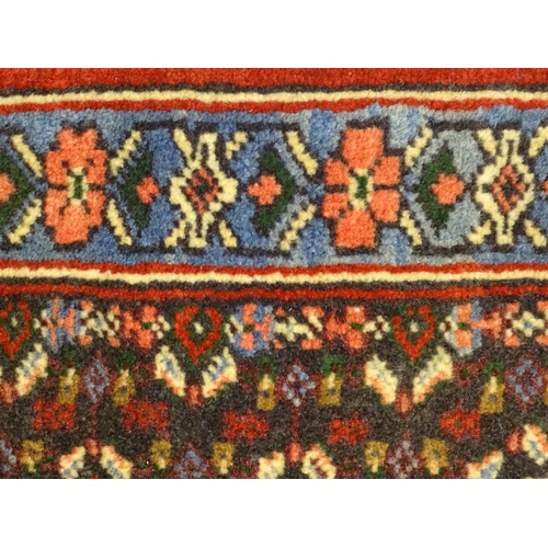 1385 - Carpet / Rug : A North West Persian Senneh runner with a red ground decorated with central repeating... 