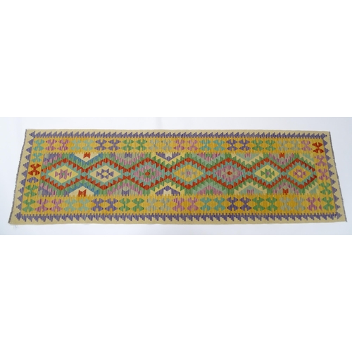 1386 - Carpet / Rug : A Turkish Anatolian kilim rug / runner with repeating geometric motifs. Approx. 34