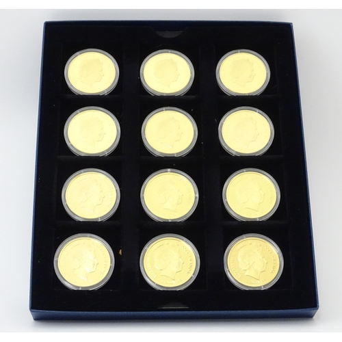 896 - Coins: A boxed set of twelve Westminster Mint gold plated medallions titled the Crown Jewels Coin Co... 