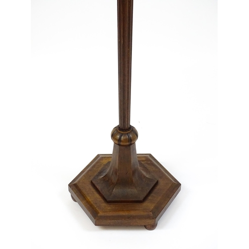 1420 - An Art Deco style oak standard lamp with a chamfered stem and a moulded hexagonal base. Approx. 56