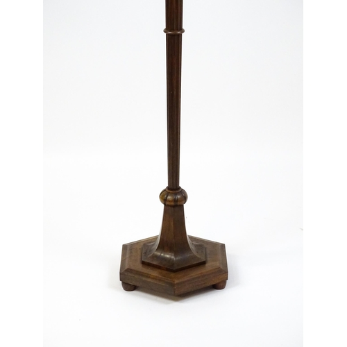 1420 - An Art Deco style oak standard lamp with a chamfered stem and a moulded hexagonal base. Approx. 56