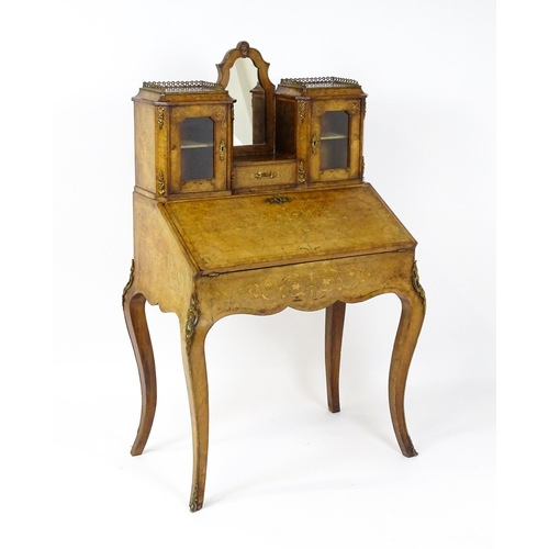 1476 - A 19thC burr walnut Bonheur du jour with a mirrored back stand and flanked by two glazed cabinets wi... 