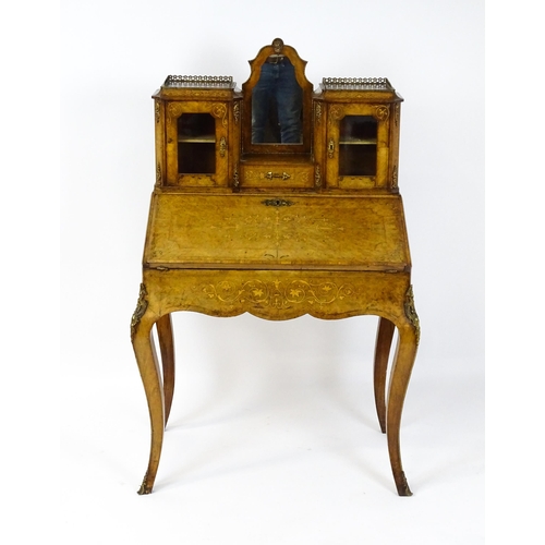 1476 - A 19thC burr walnut Bonheur du jour with a mirrored back stand and flanked by two glazed cabinets wi... 