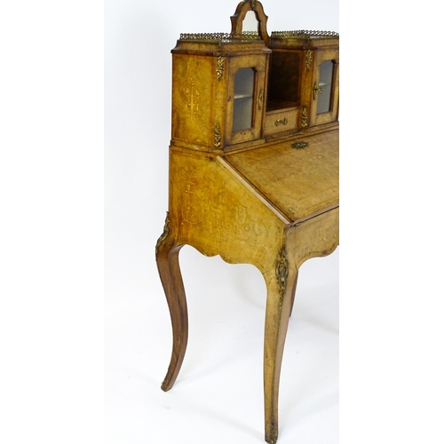 1476 - A 19thC burr walnut Bonheur du jour with a mirrored back stand and flanked by two glazed cabinets wi... 