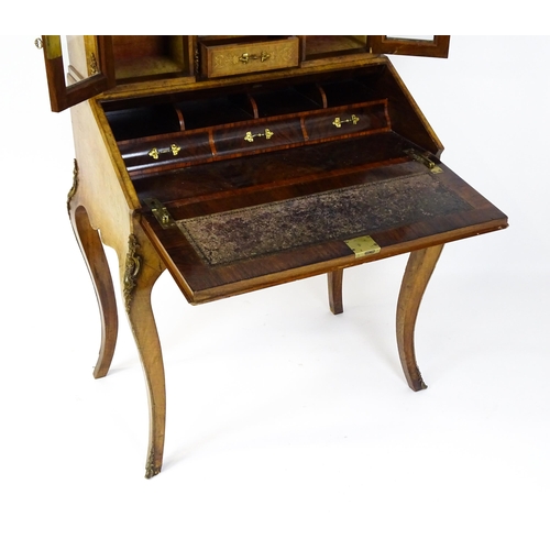 1476 - A 19thC burr walnut Bonheur du jour with a mirrored back stand and flanked by two glazed cabinets wi... 