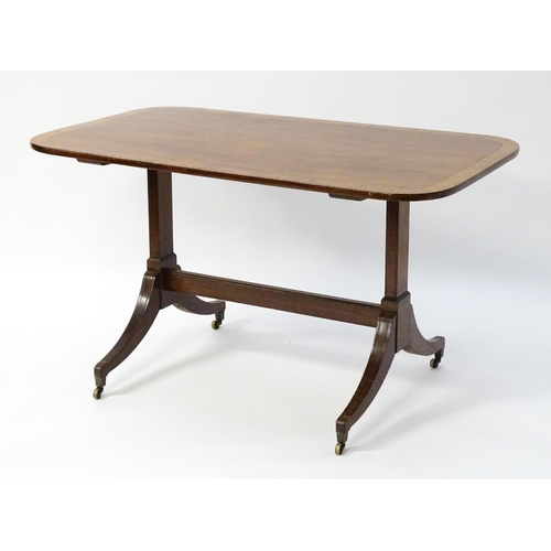 1482 - A 19thC mahogany table with a satinwood crossbanded top above twin pedestal supports and four reeded... 