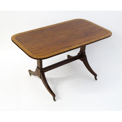 1482 - A 19thC mahogany table with a satinwood crossbanded top above twin pedestal supports and four reeded... 