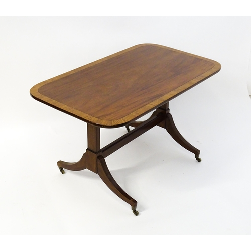 1482 - A 19thC mahogany table with a satinwood crossbanded top above twin pedestal supports and four reeded... 