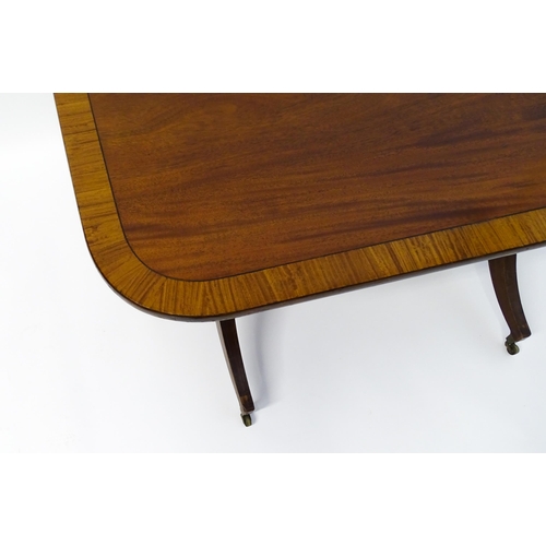 1482 - A 19thC mahogany table with a satinwood crossbanded top above twin pedestal supports and four reeded... 