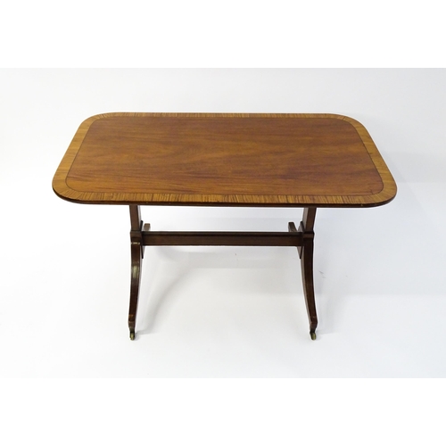 1482 - A 19thC mahogany table with a satinwood crossbanded top above twin pedestal supports and four reeded... 