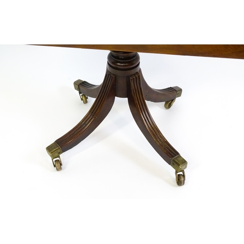 1488 - A 19thC tilt top occasional table with yew wood planked top above a reeded mahogany pedestal and fou... 