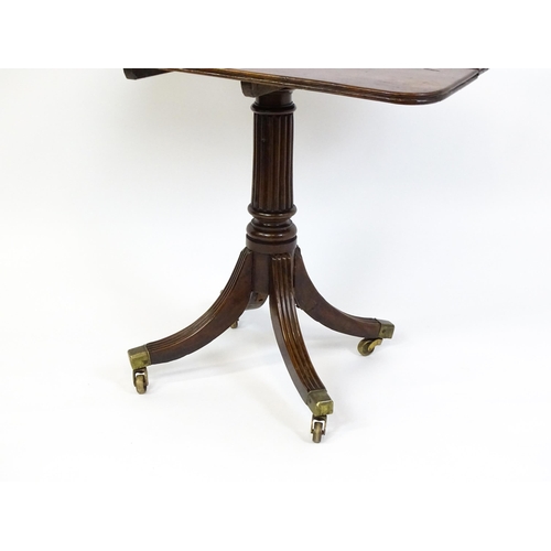 1488 - A 19thC tilt top occasional table with yew wood planked top above a reeded mahogany pedestal and fou... 