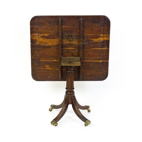 1488 - A 19thC tilt top occasional table with yew wood planked top above a reeded mahogany pedestal and fou... 