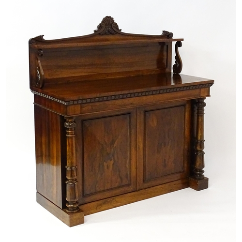 1489 - A 19thC rosewood chiffonier with a shaped upstand surmounted by a carved crest and a long shelf supp... 