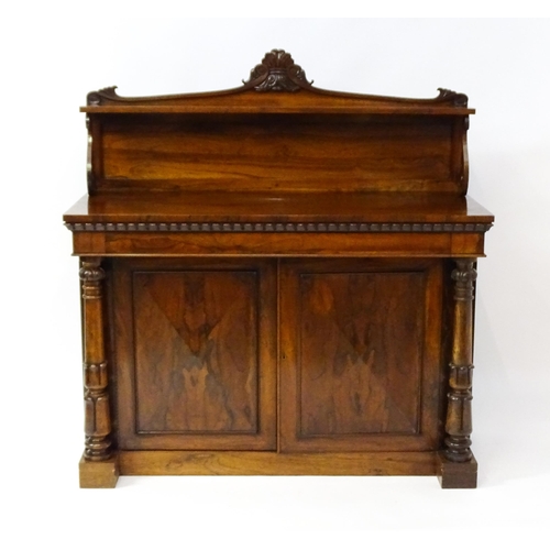 1489 - A 19thC rosewood chiffonier with a shaped upstand surmounted by a carved crest and a long shelf supp... 