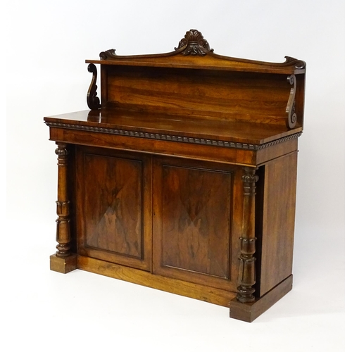 1489 - A 19thC rosewood chiffonier with a shaped upstand surmounted by a carved crest and a long shelf supp... 