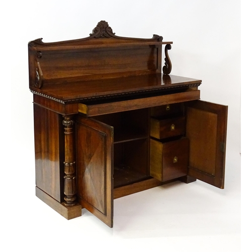 1489 - A 19thC rosewood chiffonier with a shaped upstand surmounted by a carved crest and a long shelf supp... 