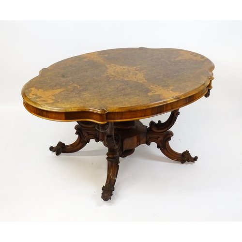 1496 - A 19thC burr walnut centre table with a moulded top above four acanthus carved supports, a large tur... 