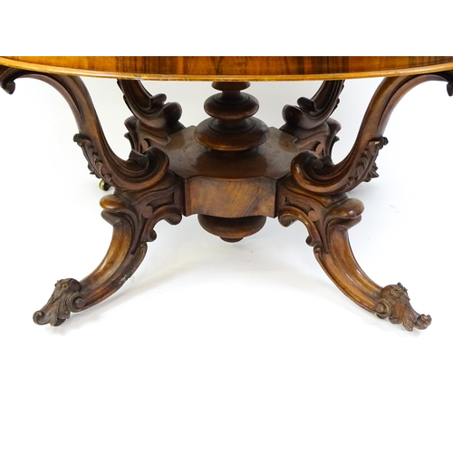 1496 - A 19thC burr walnut centre table with a moulded top above four acanthus carved supports, a large tur... 