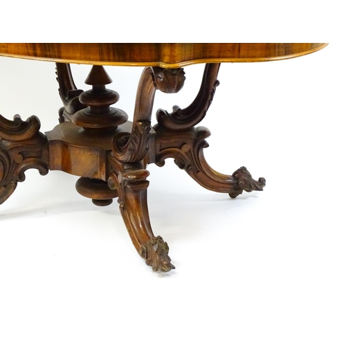 1496 - A 19thC burr walnut centre table with a moulded top above four acanthus carved supports, a large tur... 