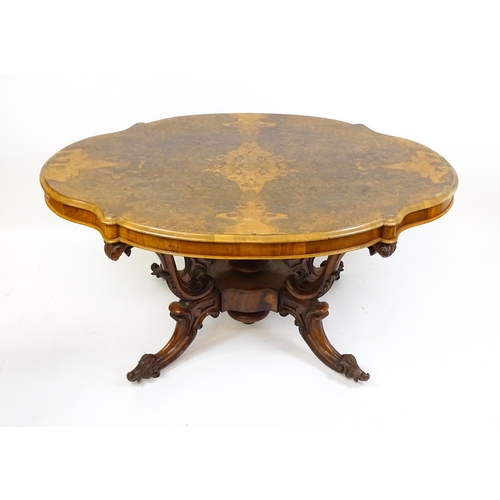 1496 - A 19thC burr walnut centre table with a moulded top above four acanthus carved supports, a large tur... 