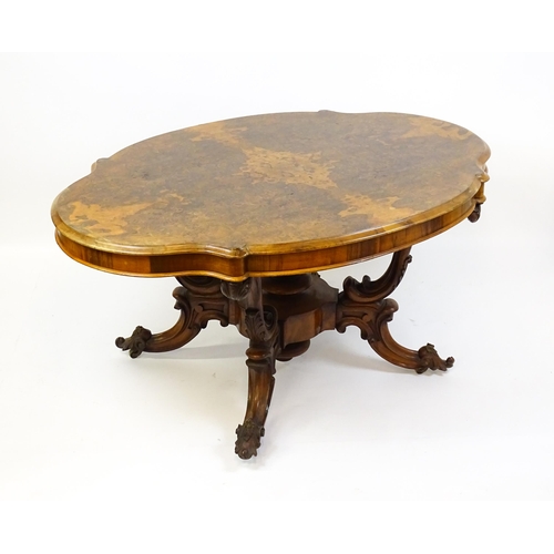 1496 - A 19thC burr walnut centre table with a moulded top above four acanthus carved supports, a large tur... 