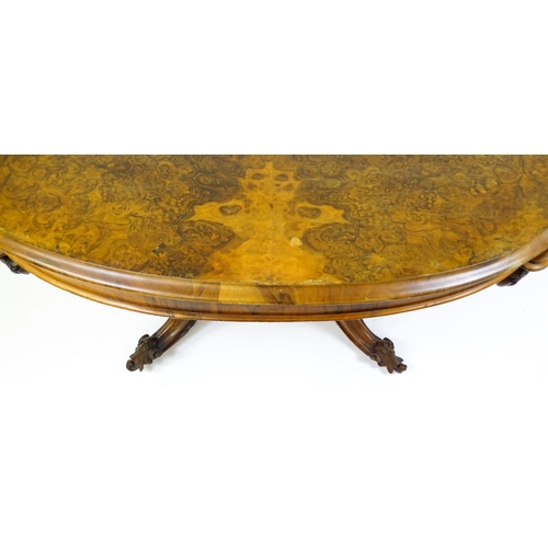 1496 - A 19thC burr walnut centre table with a moulded top above four acanthus carved supports, a large tur... 