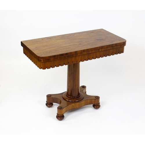 1504 - A 19thC mahogany tea table / card table with a hinged, revolving top above a turned pedestal and app... 