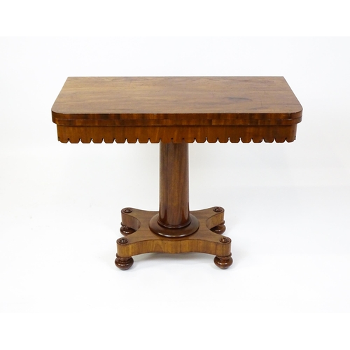 1504 - A 19thC mahogany tea table / card table with a hinged, revolving top above a turned pedestal and app... 