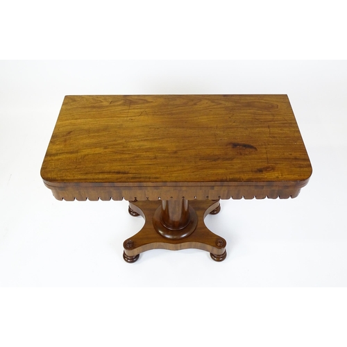 1504 - A 19thC mahogany tea table / card table with a hinged, revolving top above a turned pedestal and app... 