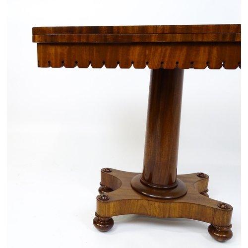 1504 - A 19thC mahogany tea table / card table with a hinged, revolving top above a turned pedestal and app... 