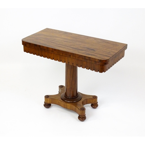 1504 - A 19thC mahogany tea table / card table with a hinged, revolving top above a turned pedestal and app... 