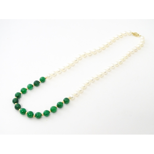 727 - A necklace of jade beads and pearls with 14ct gold clasp. Approx 18