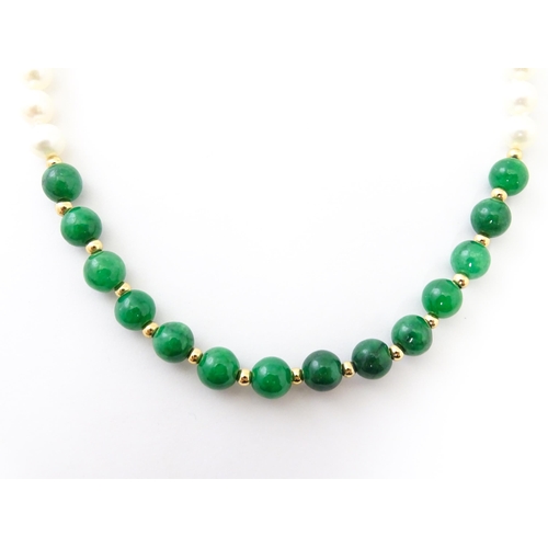 727 - A necklace of jade beads and pearls with 14ct gold clasp. Approx 18