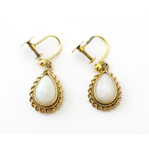 739 - A pair of 9ct gold drop earrings set with opals. Approx 1