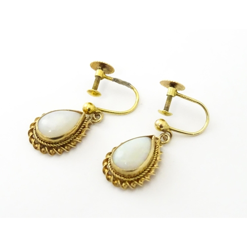 739 - A pair of 9ct gold drop earrings set with opals. Approx 1