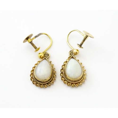 739 - A pair of 9ct gold drop earrings set with opals. Approx 1