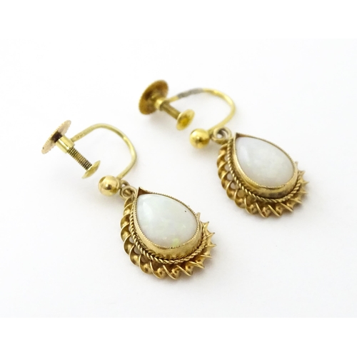 739 - A pair of 9ct gold drop earrings set with opals. Approx 1