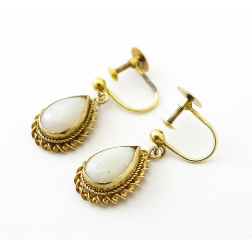 739 - A pair of 9ct gold drop earrings set with opals. Approx 1