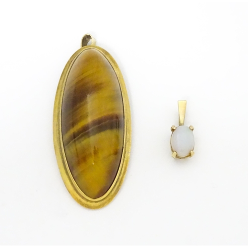 742 - A 9ct gold pendant set with opal together with a pendant set with tigers eye cabochon. Approx 1 1/2