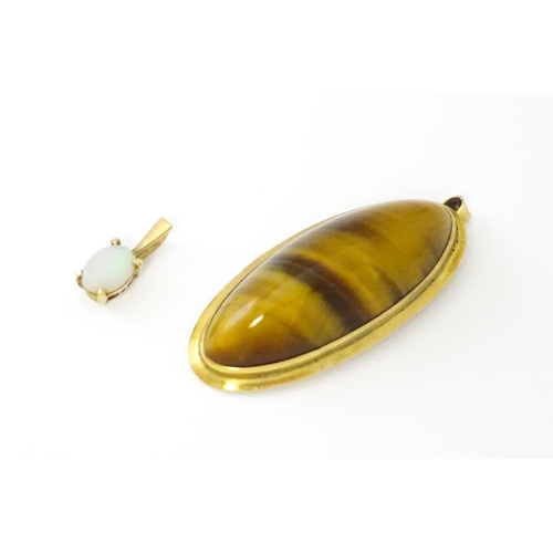 742 - A 9ct gold pendant set with opal together with a pendant set with tigers eye cabochon. Approx 1 1/2